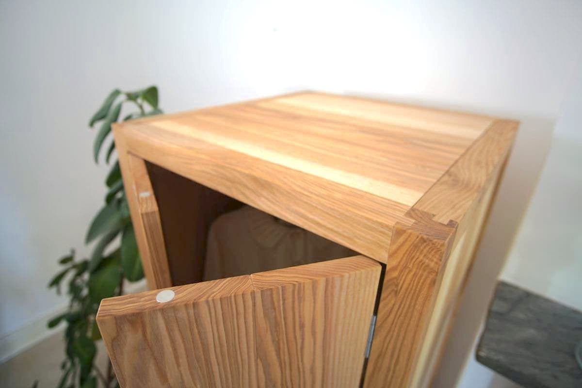 a wooden cabinet with a white coat and shoes