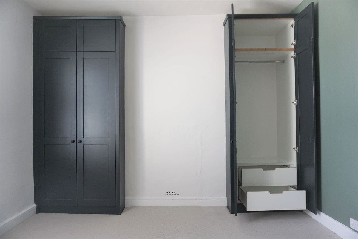 Bedroom with Black Shaker Wardrobes one open with white interior and drawers