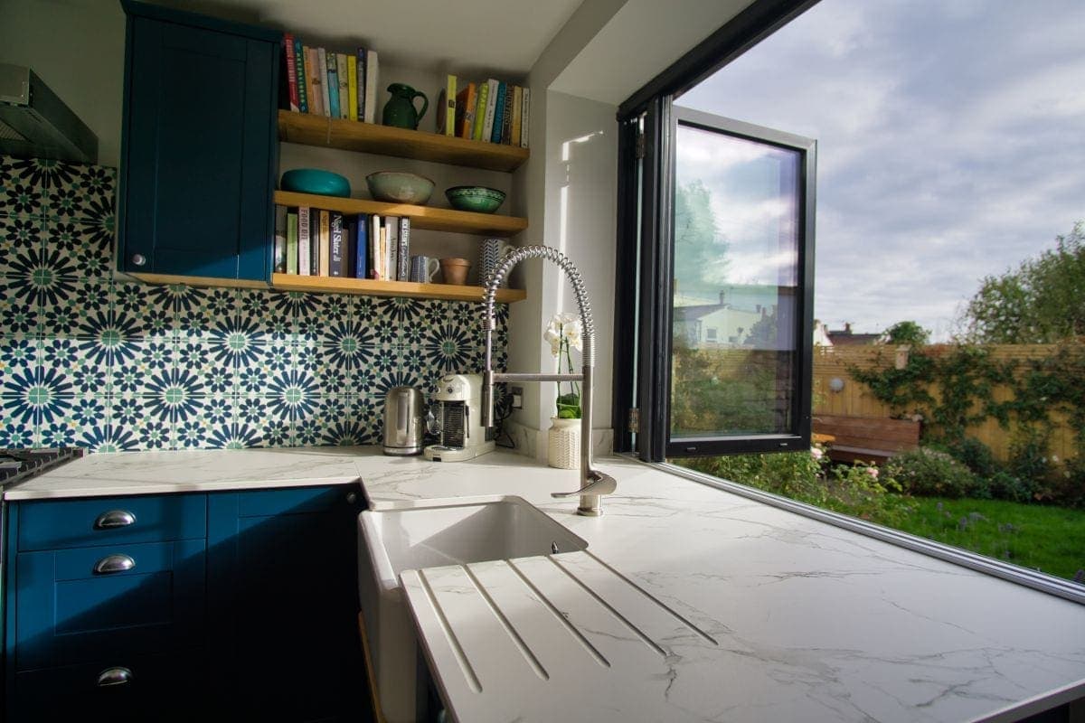 a kitchen with a bi fold window and a belfast sink