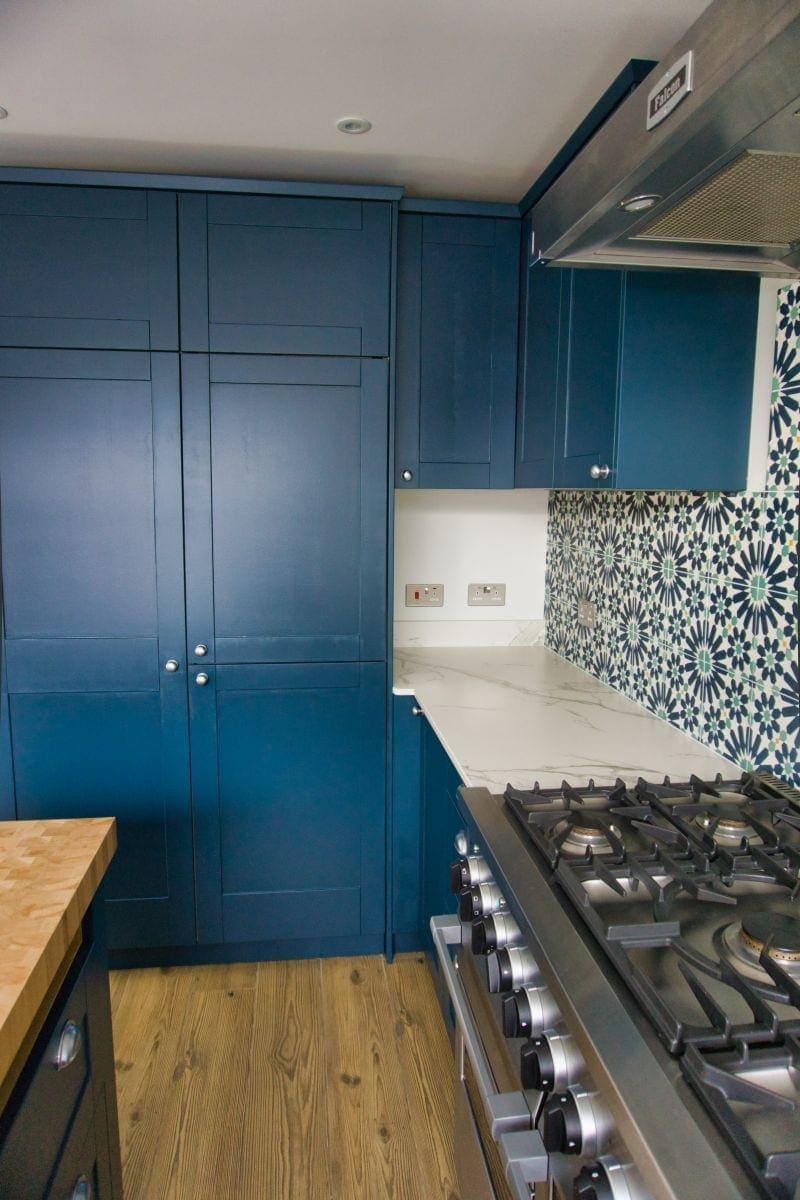 a kitchen with blue cabinets and stove