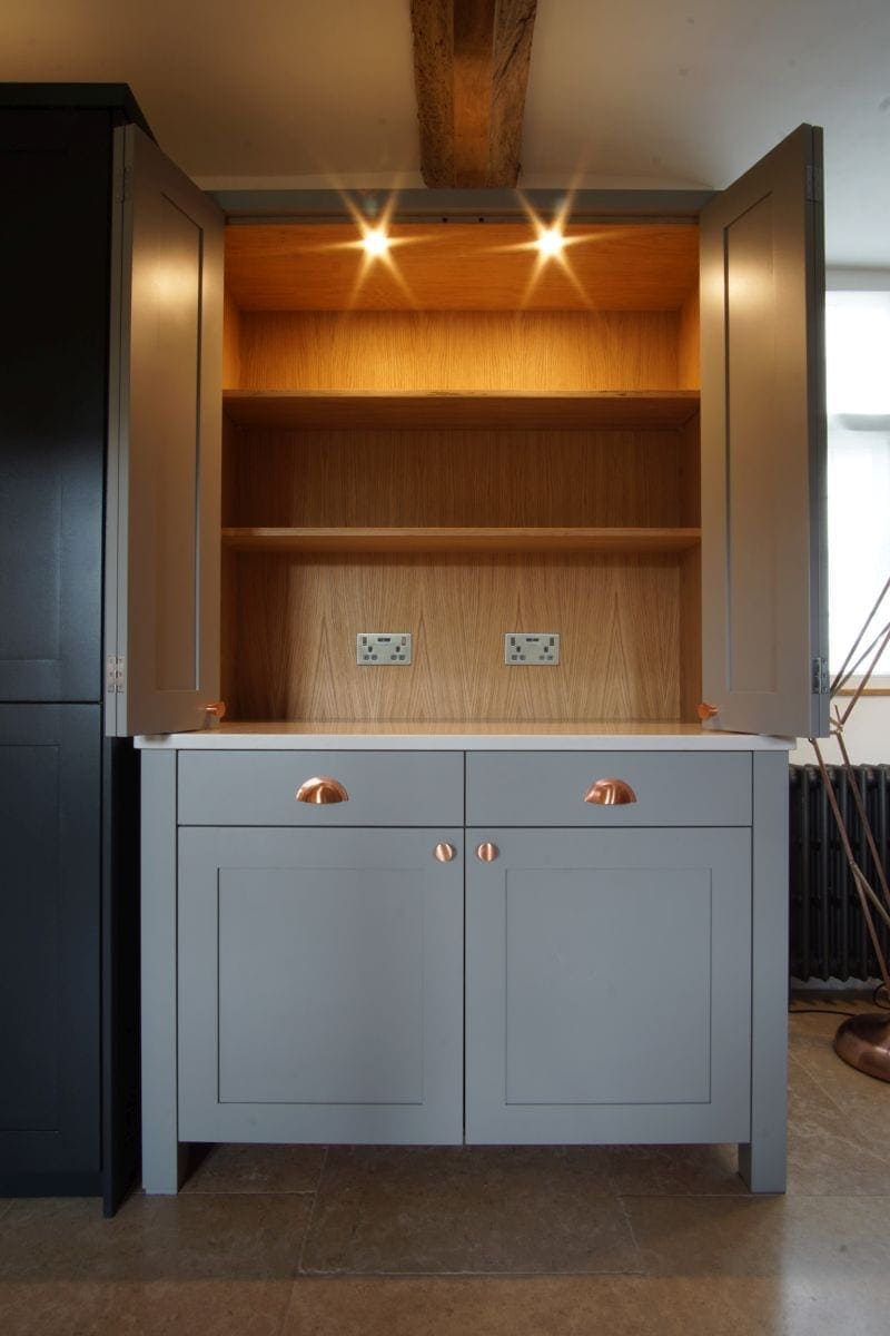 a grey welsh dresser with lights on