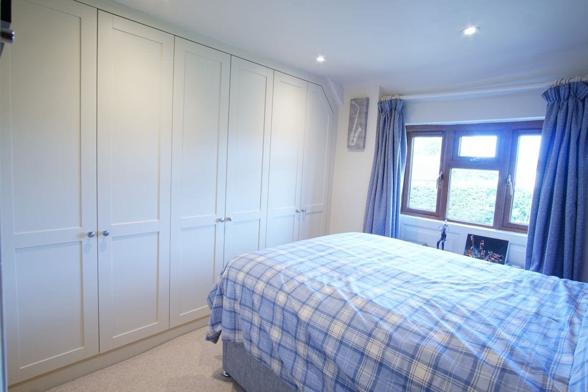 a bedroom with a bed and white cabinets