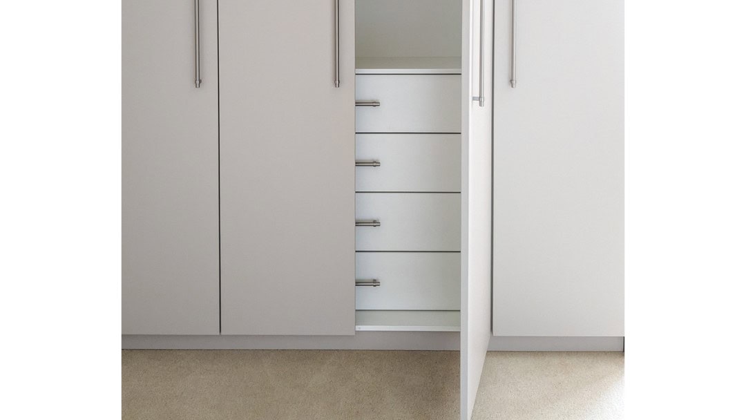 A white wardrobe with drawers and a door.