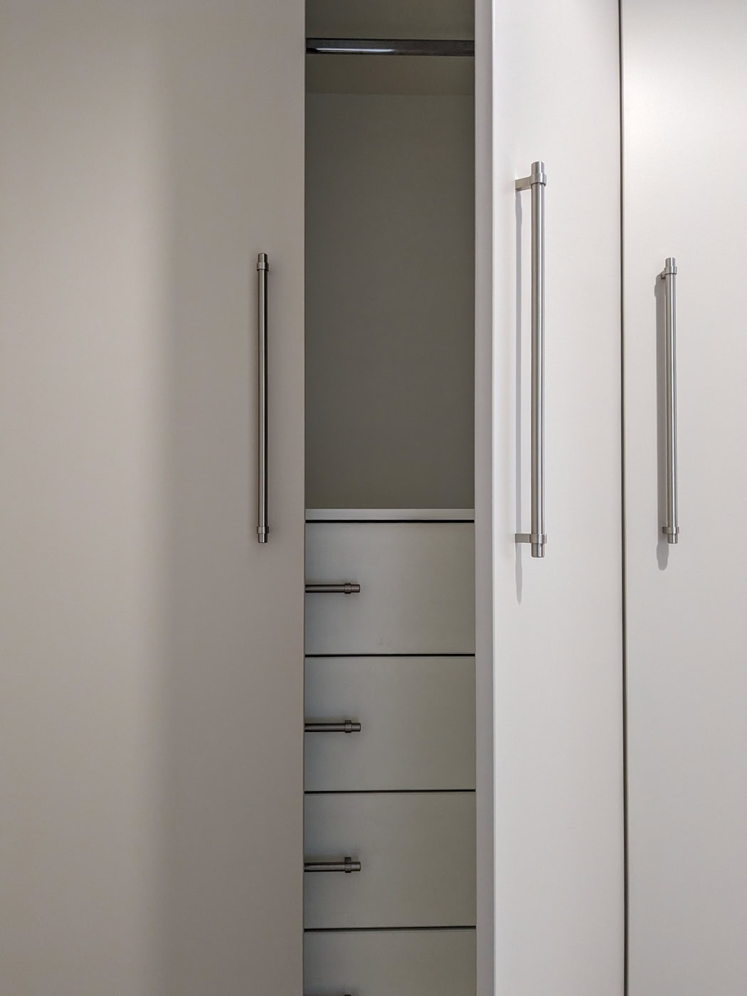 Bespoke fitted wardrobe in Winterbourne, near Bristol, featuring a simple yet elegant design with a Farrow & Ball Roasted Macadamia finish, four interior drawers on full extension soft close runners, and ample hanging space with sleek, simple handles.