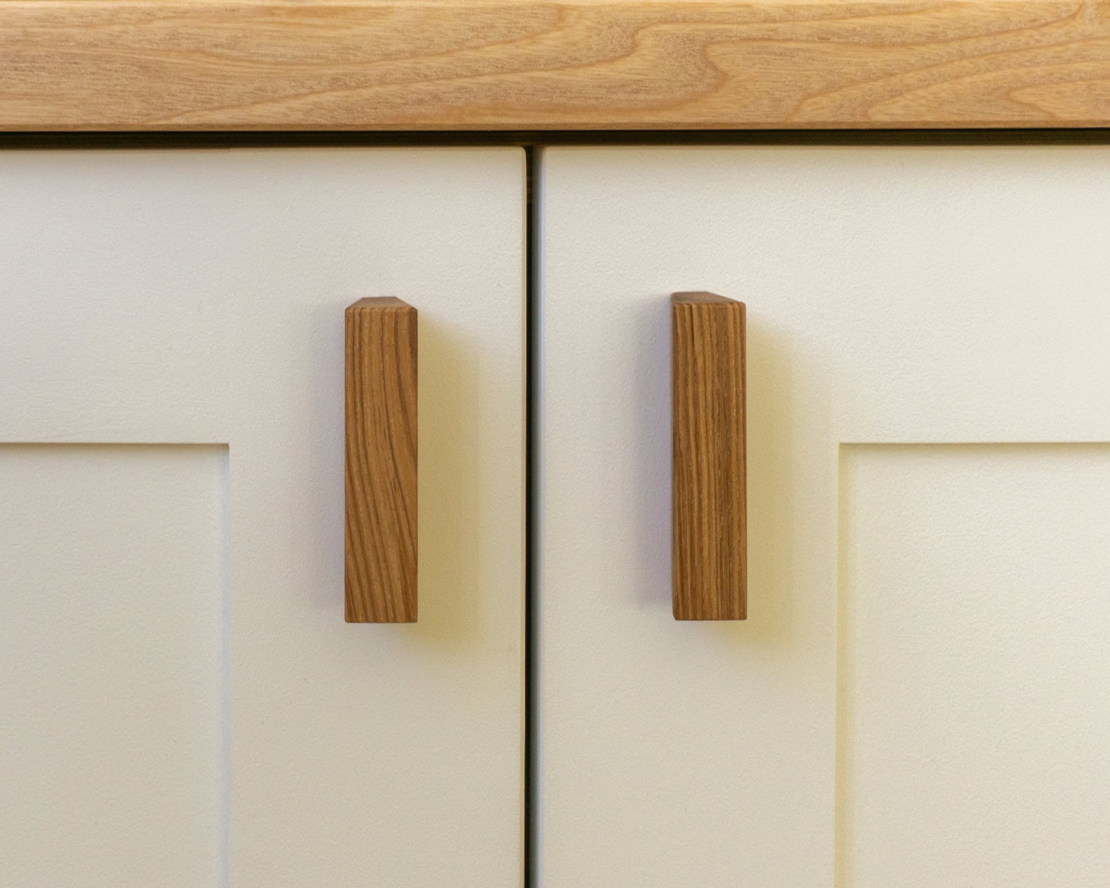 Left-side view of a custom-fitted alcove cabinet and TV with white painted finish and ash wood detailing.