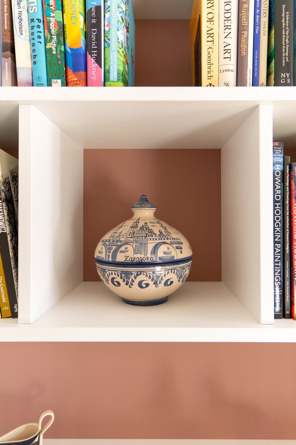 a white shelf with a blue and white vase on it