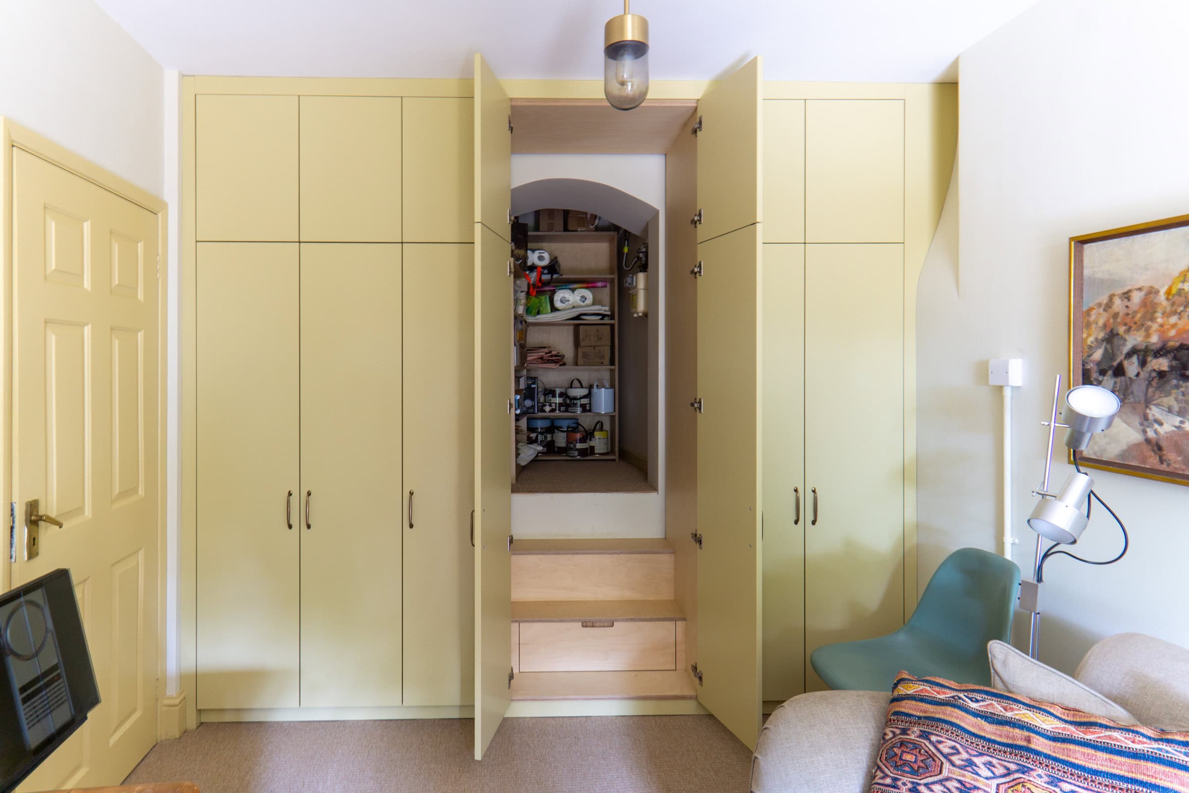 run of yellow wardrobes with a secret door through to a cellar