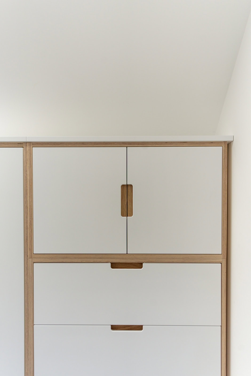 Fitted loft wardrobe designed around a 45 degree sloping ceiling